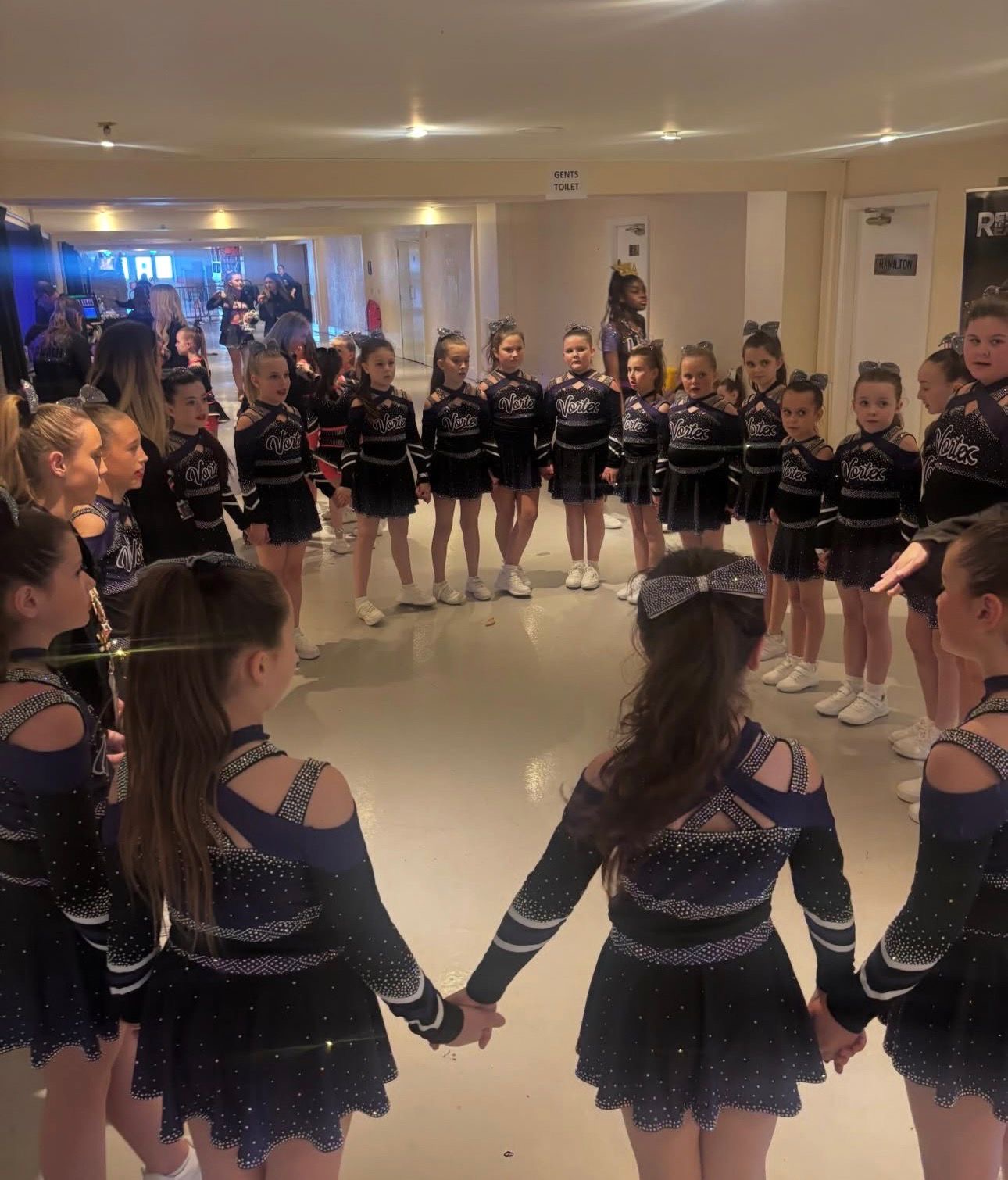 Vortex athletes in a team huddle before performing